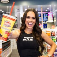 Woman holding a One Stop Nutrition smoothie cup