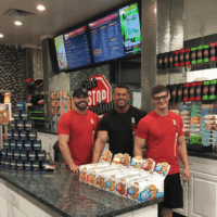 One Stop Nutrition employees smiling behind counter