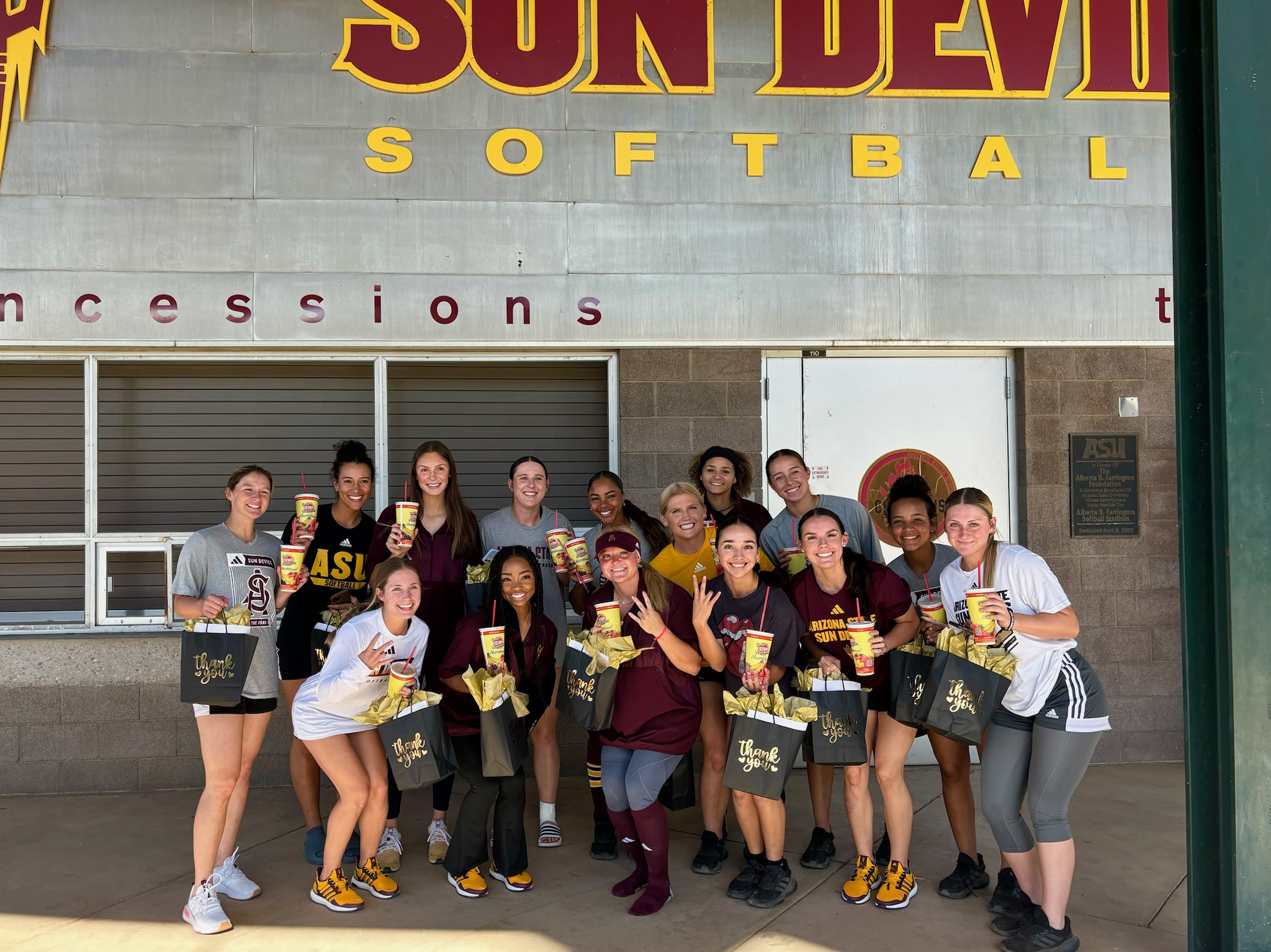 Arizona State University students posing with One Stop Nutrition to-go cups on campus