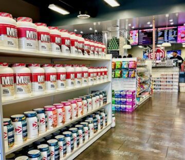 Retail interior of a One Stop Nutrition franchise showing product inventory and protein powder displays.